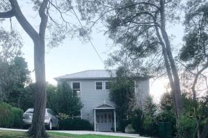 a white house with a garage in front of it at La Perouse Lorne in Lorne