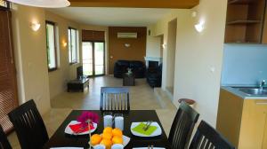 a dining room and kitchen with a table with fruit on it at Вила Ваня - Villa Vania in Bŭlgarevo