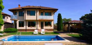 a house with a swimming pool in front of a house at Вила Ваня - Villa Vania in Bŭlgarevo