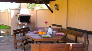 a wooden table with two chairs and a table with food on it at Вила Ваня - Villa Vania in Bŭlgarevo