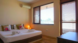 a bedroom with a bed with two towels on it at Вила Ваня - Villa Vania in Bŭlgarevo +50 photos