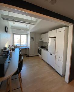 a kitchen with white cabinets and a table with chairs at Hostel400Kokkola Extend in Kokkola