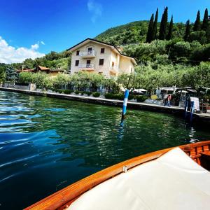 a boat in a river with a house in the background at La Foresta Monteisola in Monte Isola