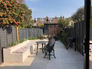 a patio with a table and chairs and a fence at Boutique home near Chichester centre in Chichester
