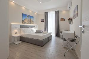 a bedroom with a bed and a desk and a chair at Esseneto Rooms in Agrigento