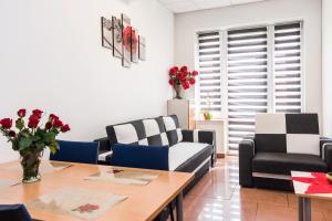 a living room with couches and a table with flowers on it at Apartament Solny Wieliczka Centrum 5 in Wieliczka