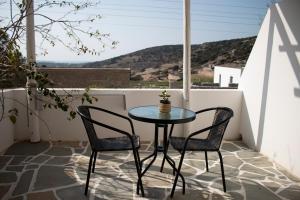 a small table and two chairs on a balcony at AGNADEMA Luxury Residences in Schinoussa