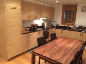 a kitchen with a wooden table and a wooden floor at Ski Paradise MOUNTAIN & LUXE apartments in Veysonnaz