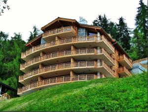 Ski Paradise SP 012 - MOUNTAIN apartment 8 pers في فييسوناز: مبنى كبير على قمة تل أخضر