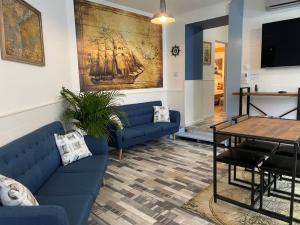 a living room with blue couches and a table at Dunakavics Boutique Apartman Szentendre in Szentendre