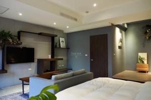 een slaapkamer met een bed, een bank en een televisie bij ManMan B&B in Jian
