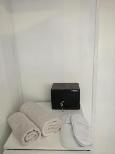 ein Regal mit Handtüchern und einen TV an der Wand in der Unterkunft Santo Spiti sou 6 in Fira
