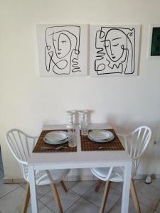 a white table with two chairs and a white table with plates at Santo Spiti sou 6 in Fira +17 photos