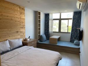 una camera con letto e finestra con panca di Chingya House a Beigan