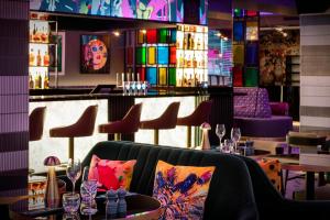 een restaurant met een bar met stoelen en tafels bij NYX Hotel London Holborn by Leonardo Hotels in Londen