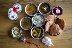 a table with various dishes of food on it at Ganga Heritage By Howard in Haridwār