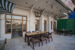 uma sala de jantar com mesa e cadeiras de madeira em Ganga Heritage By Howard em Haridwār