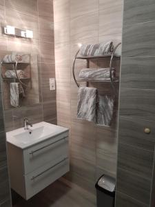 a bathroom with a sink and a toilet and towels at Flamingó Apartmanház in Hévíz