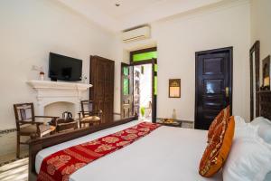 a bedroom with a bed and a tv and a fireplace at Ganga Heritage By Howard in Haridwār