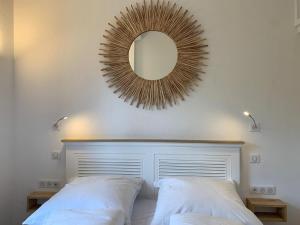 a mirror on the wall above a bed in a bedroom at Au bord de la mer in Cavalaire-sur-Mer