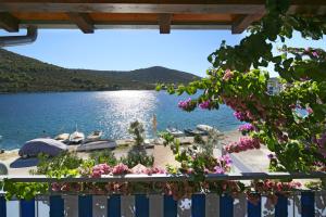 uma vista para um lago a partir de uma varanda com flores em Apartment Ema em Vinišće