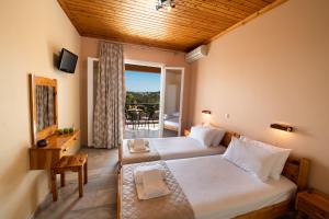 a hotel room with two beds and a balcony at Artemis Pension by Imagine Lefkada in Lygia
