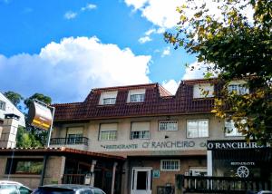 um edifício com um telhado vermelho numa rua em HOSTAL Restaurante RANCHEIRO em Vigo