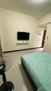 - une chambre avec un lit et une télévision à écran plat dans l'établissement Murakami Travel Guest House, à Huxi