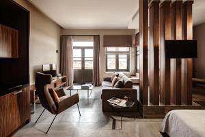 a living room with a couch and a chair and a tv at 1926 Le Parisot Boutique Suites in Valletta