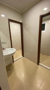 La salle de bains est pourvue d'un lavabo et d'un miroir. dans l'établissement Murakami Travel Guest House, à Huxi