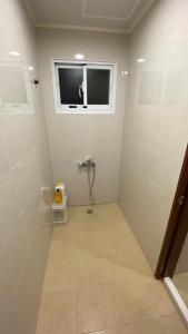 La salle de bains est pourvue d'une douche et d'une fenêtre. dans l'établissement Murakami Travel Guest House, à Huxi