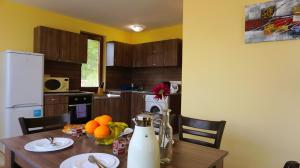 a kitchen with a wooden table with fruit on it at Вила Марна - Villa Marna in Bŭlgarevo