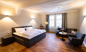 Hotel1601 Inklusionsunternehmen في Treffurt: غرفة نوم بسرير كبير وغرفة معيشة