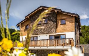 a log home with a balcony and a wood at Horská Chata Ostružiny in Donovaly