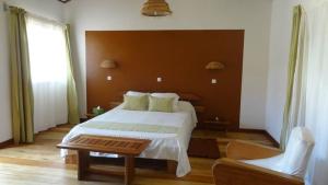 sypialnia z dużym łóżkiem i dużym oknem w obiekcie Couleur Café w mieście Antsirabe