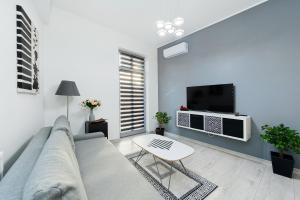 a living room with a couch and a table and a tv at Apartament Solny Centrum Wieliczka 11 in Wieliczka