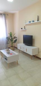 een woonkamer met een tv en een salontafel bij Casa Mercedes in Rota
