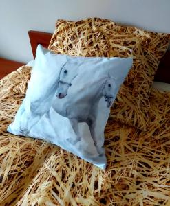 a pillow with two sheep on it sitting on a bed at Centrum Turystyczno- Rehabilitacyjne in Krzyżewo