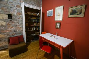 une chambre rouge avec une table et une étagère à livres dans l'établissement The monumental house, à Athènes