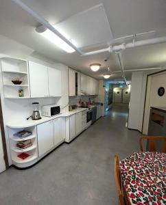 eine Küche mit weißen Schränken und einem Tisch im Zimmer in der Unterkunft Hostel400Kokkola in Kokkola
