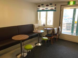 una sala de espera con 2 mesas y un sofá en Hostel400Kokkola en Kokkola