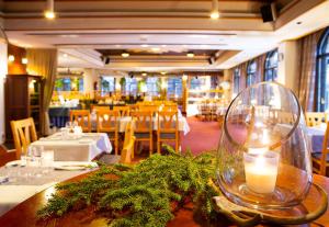 a restaurant with a table with a candle on it at Lapland Hotels Riekonlinna in Saariselka