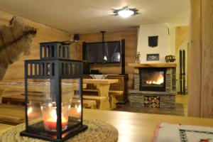 a living room with a fireplace and a table at Michałowa Chata in Poronin