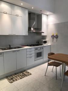 uma cozinha com armários brancos e uma mesa de madeira em Casa Tigullio em Rapallo