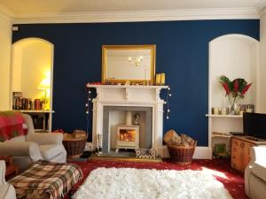a living room with a fireplace and a mirror at Glenan Lodge Self Catering in Tomatin