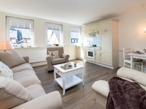 a living room with two couches and a table at Dünenrose in Tinnum