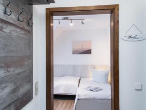 a mirror in a room with a bed at Dünenrose in Tinnum