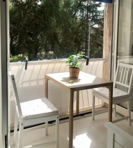 モノーポリにあるMagentaのポーチにテーブルと椅子2脚と鉢植え