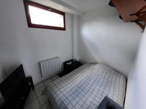 - une petite chambre avec un lit et une fenêtre dans l'établissement Proche Zone Industrielle Wi-Fi Netflix, à Maubeuge