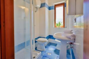 een blauwe en witte badkamer met een toilet en een wastafel bij Paolino Housing in Paestum +43 foto's